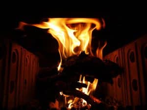 Stark loderndes Feuer in einem dunklen Herd – Sinnbild für Erwachen, die Auseinandersetzung mit zerstörerischen Kräften und schamanische Erkenntnis.
