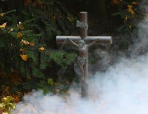 Kreuz, das aus dichtem Nebel aufsteigt – Symbol für den Kreuzweg und die geistigen Prüfungen in der schamanischen Ausbildung.