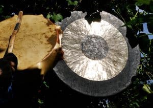 Schamanische Ausbildung Seminar 2. Gong mit seitlich angeordneter Trommel in geheimnisvoller, magischer Lichtstimmung – Sinnbild für schamanische Attribute, rituelle Klänge und geistige Verbundenheit.